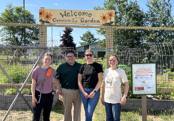 People standing in front of a community garden